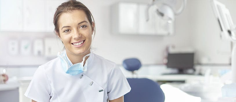 Smiling dental assistant in an empty dentist office