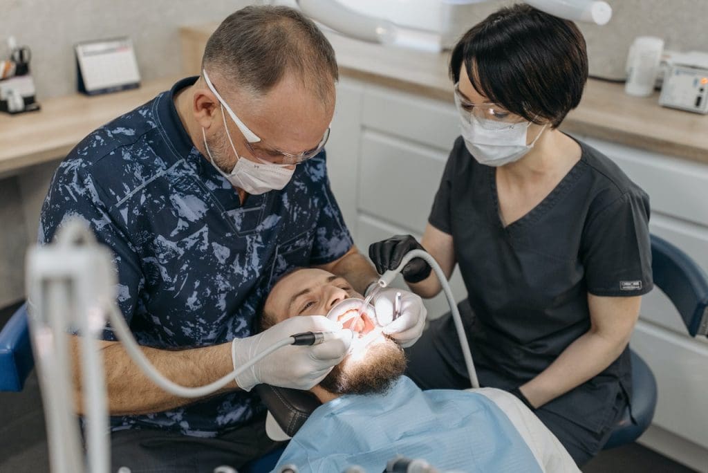 dentist working with assistant to treat patient